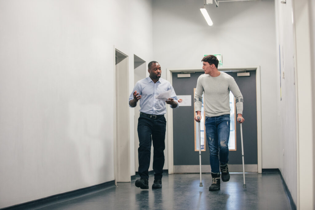 injured-man-returning-to-work-and-speaking-with-coworker