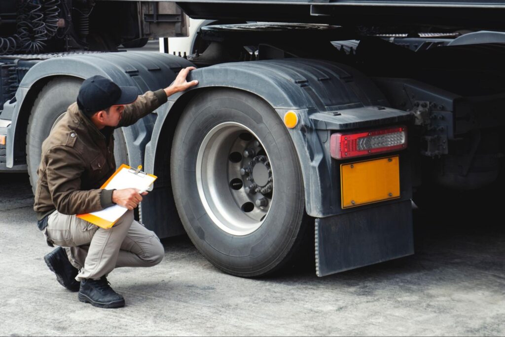 man-conducting-truck-maintenance-on-tractor-trailor